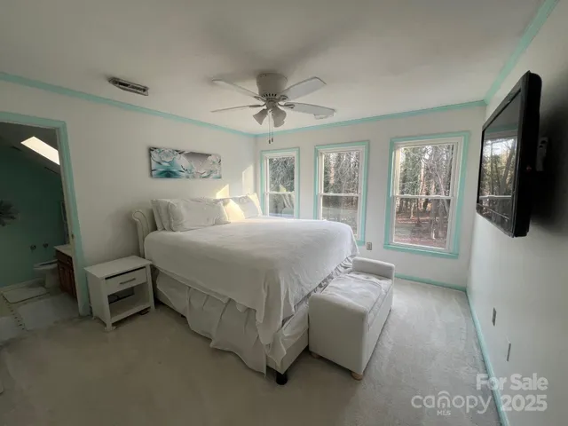a bedroom with a large bed a flat tv screen and dresser