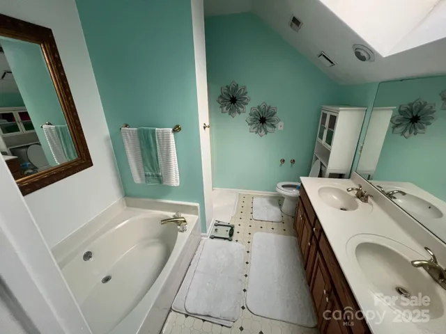 a bathroom with a tub sink and mirror