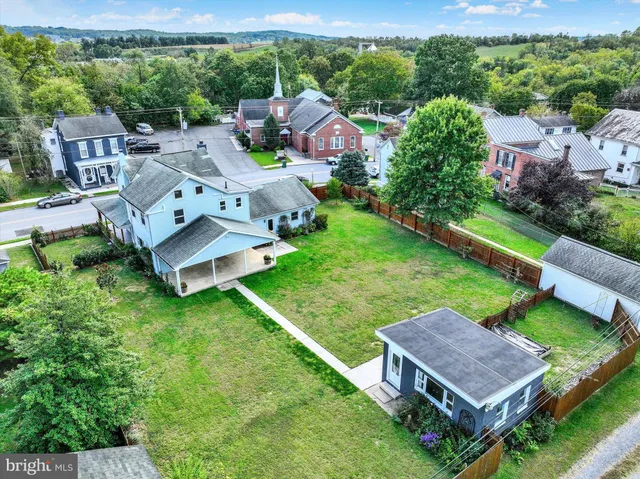 an aerial view of residential house with outdoor space and trees all around
