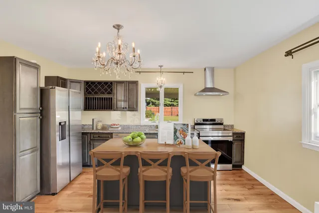 a view of a dining room with furniture a chandelier and wooden floor
