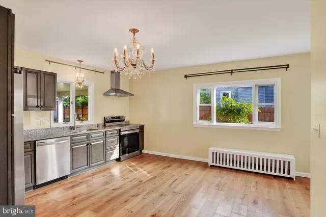 a large kitchen with kitchen island white cabinets and stainless steel appliances
