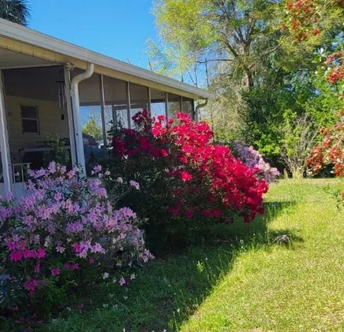 a front view of a house with a yard and fountain