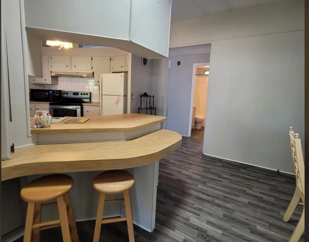 a kitchen with stainless steel appliances kitchen island a table and chairs in it