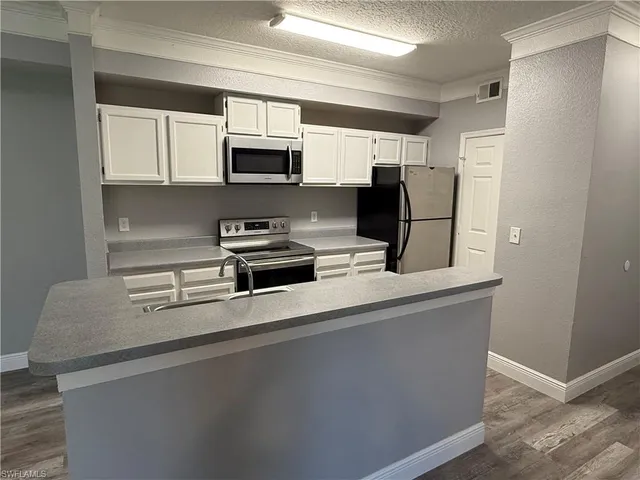 a kitchen with stainless steel appliances a microwave a sink and cabinets