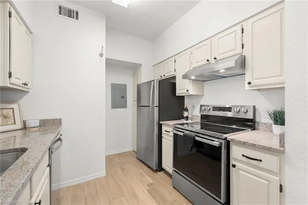 a kitchen with stainless steel appliances granite countertop a sink stove and refrigerator