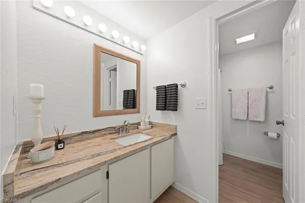 a bathroom with a granite countertop sink a large mirror and a shower