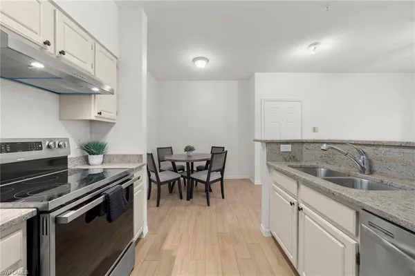 a kitchen with a sink and chairs