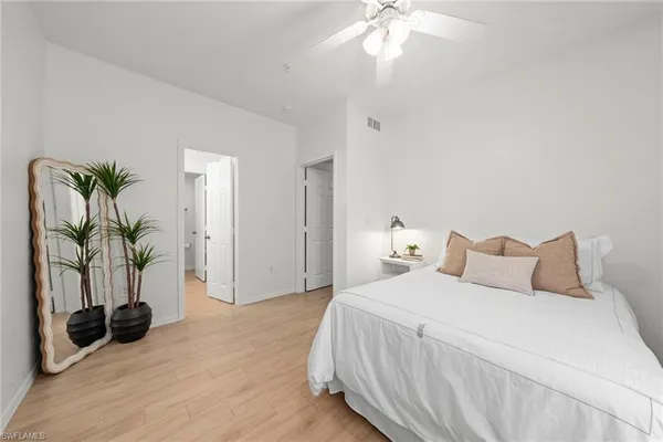 a bedroom with a bed and a potted plant