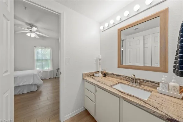 a en suite bathroom with a granite countertop sink and a mirror