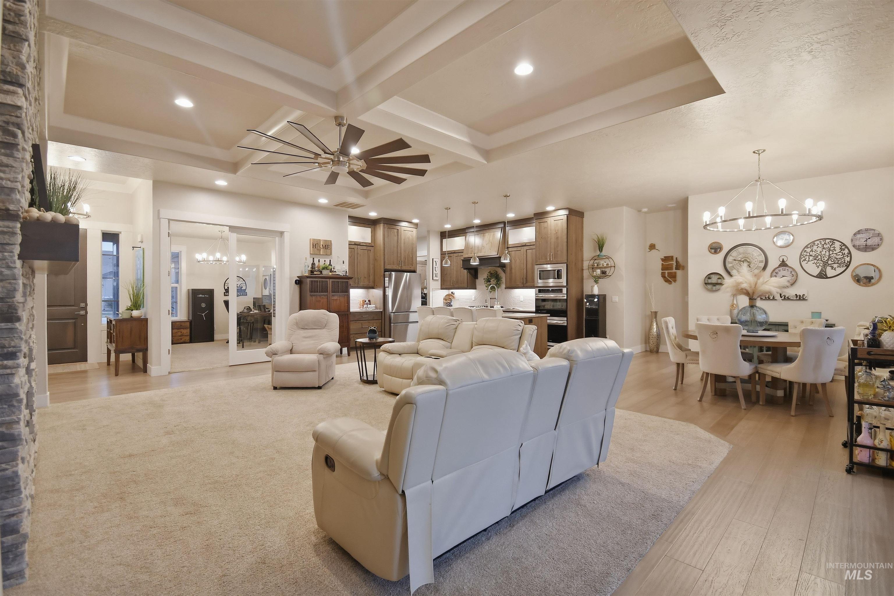 12174 West Lacerta Street Star, ID 83669 - Photo 11 of 49 Living area with a chandelier, ceiling fan, coffered ceiling, and light wood-style flooring