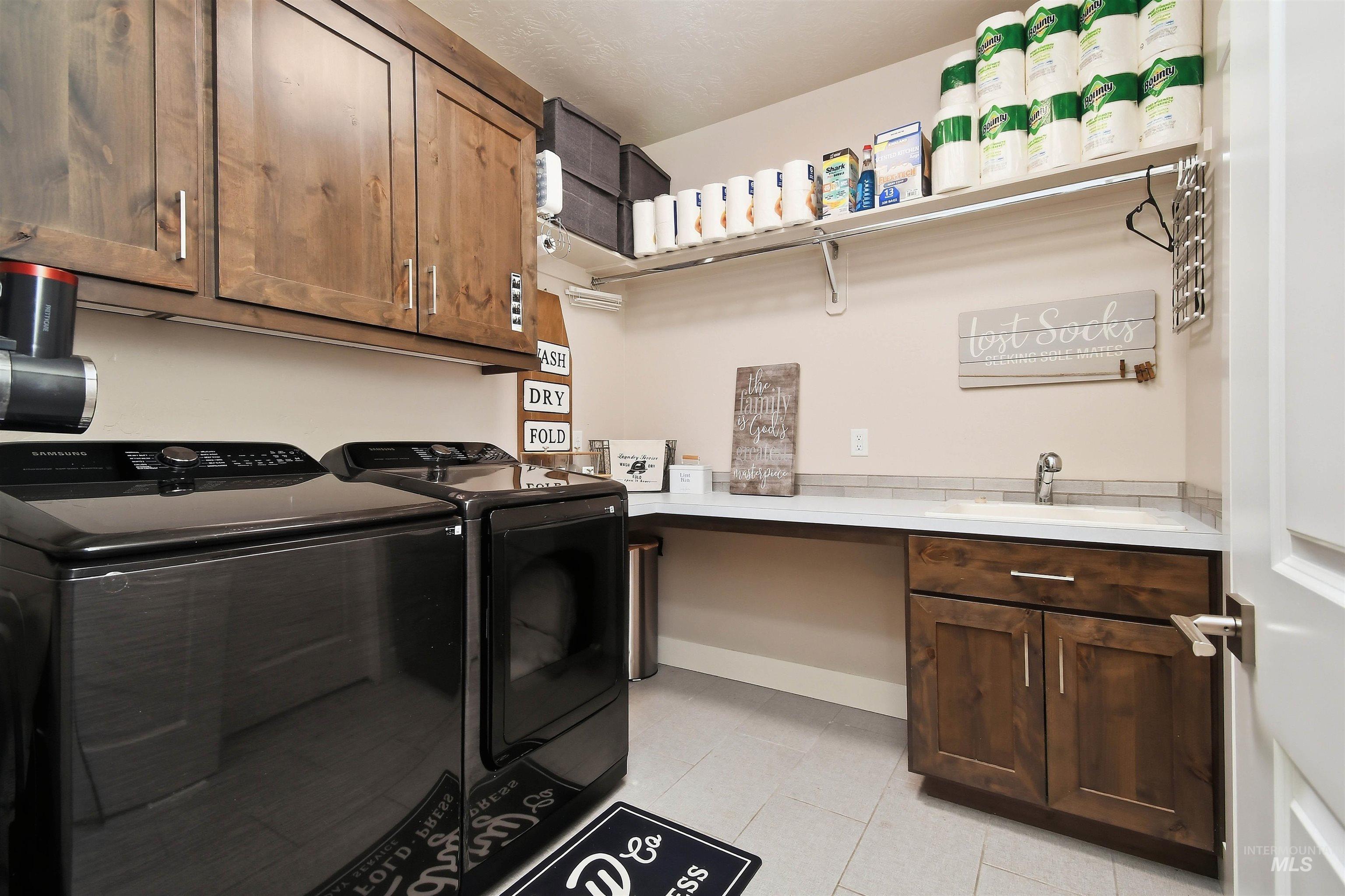 12174 West Lacerta Street Star, ID 83669 - Photo 29 of 49 Laundry area with washing machine and dryer and cabinet space