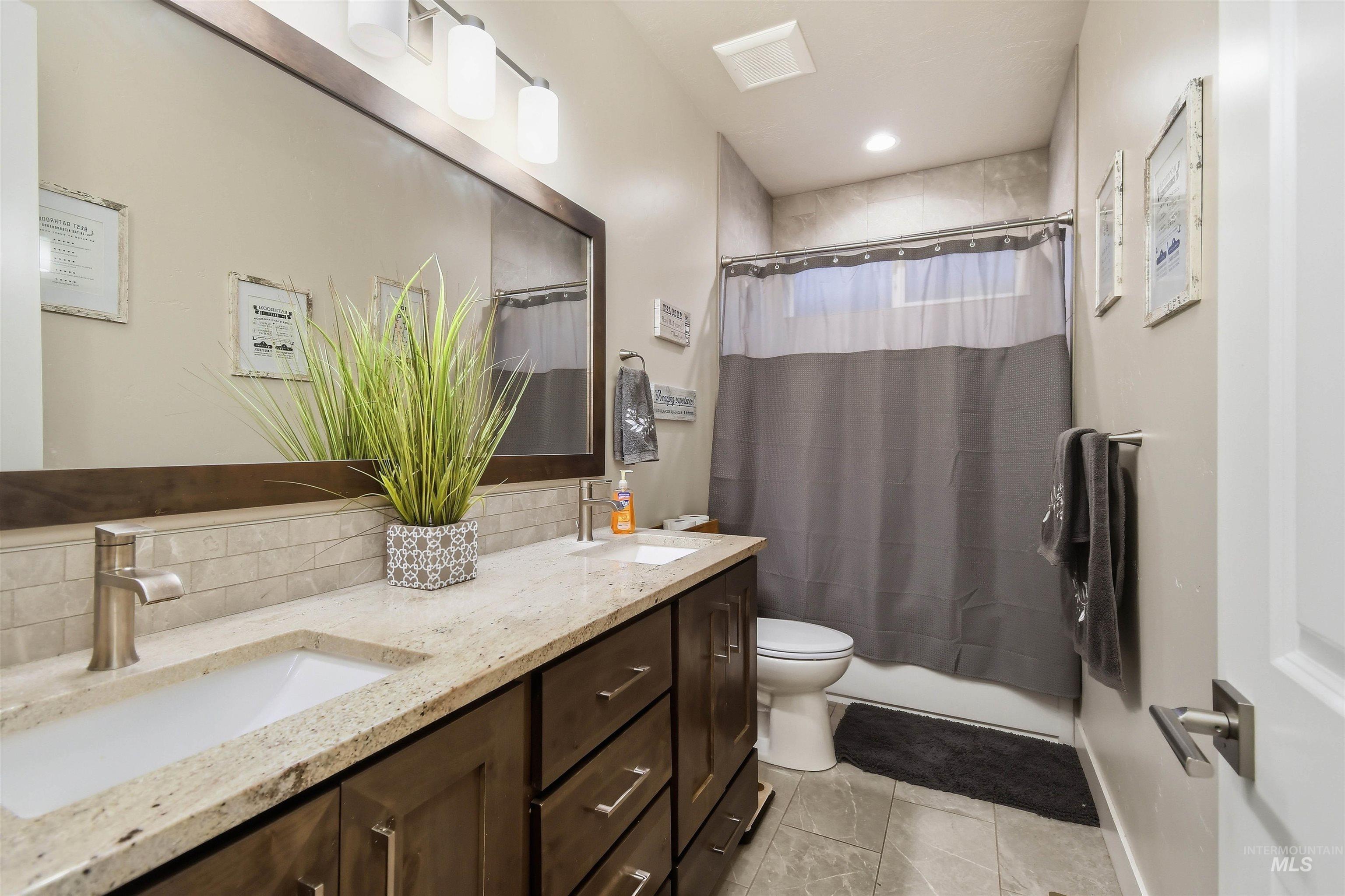 12174 West Lacerta Street Star, ID 83669 - Photo 35 of 49 Full bath featuring double vanity, shower / tub combo with curtain, backsplash, and recessed lighting