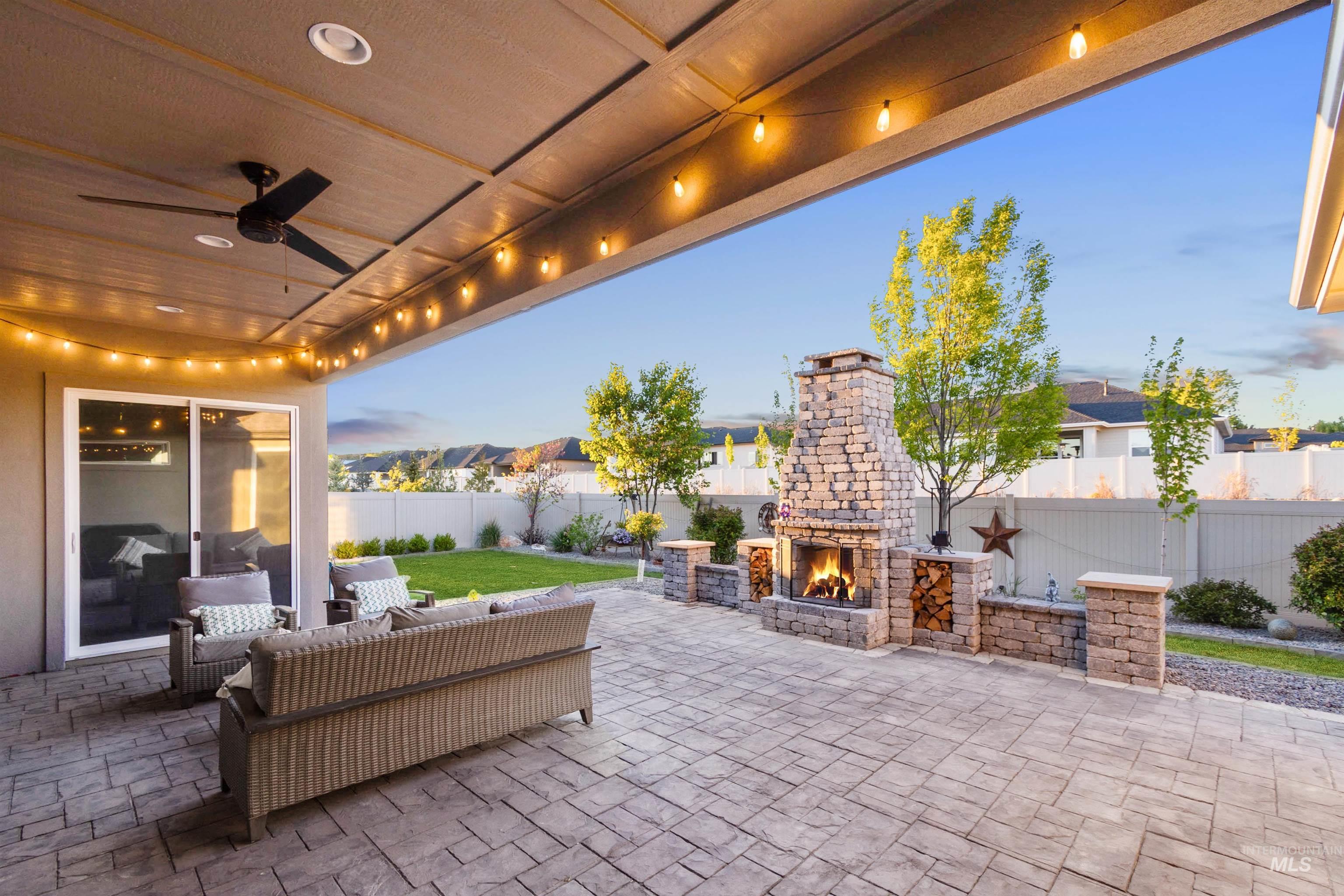 12174 West Lacerta Street Star, ID 83669 - Photo 38 of 49 Patio terrace at dusk with a patio area, an outdoor living space with a fireplace, a fenced backyard, and ceiling fan