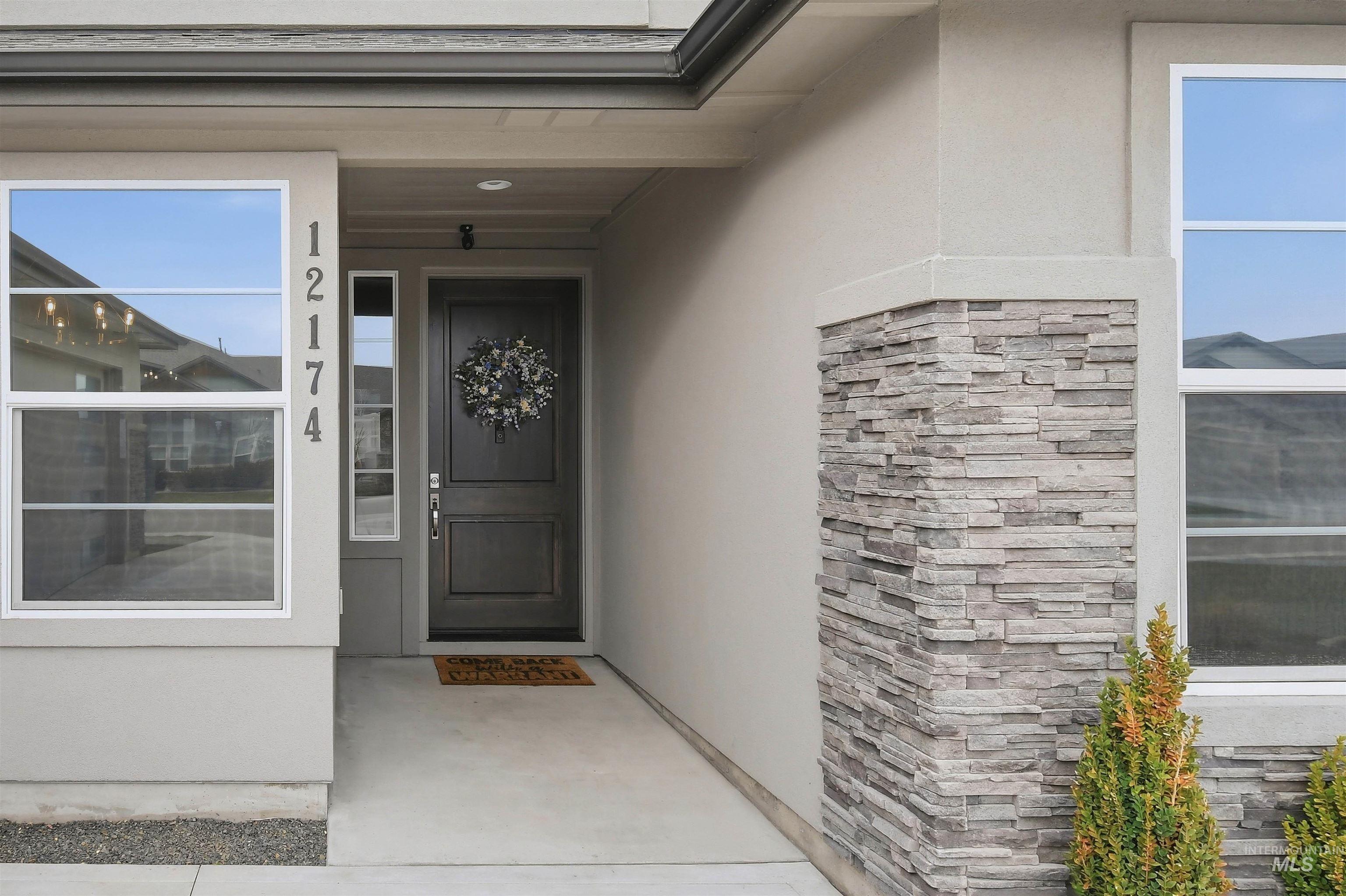 12174 West Lacerta Street Star, ID 83669 - Photo 5 of 49 View of exterior entry with stucco siding, stone siding, and a porch