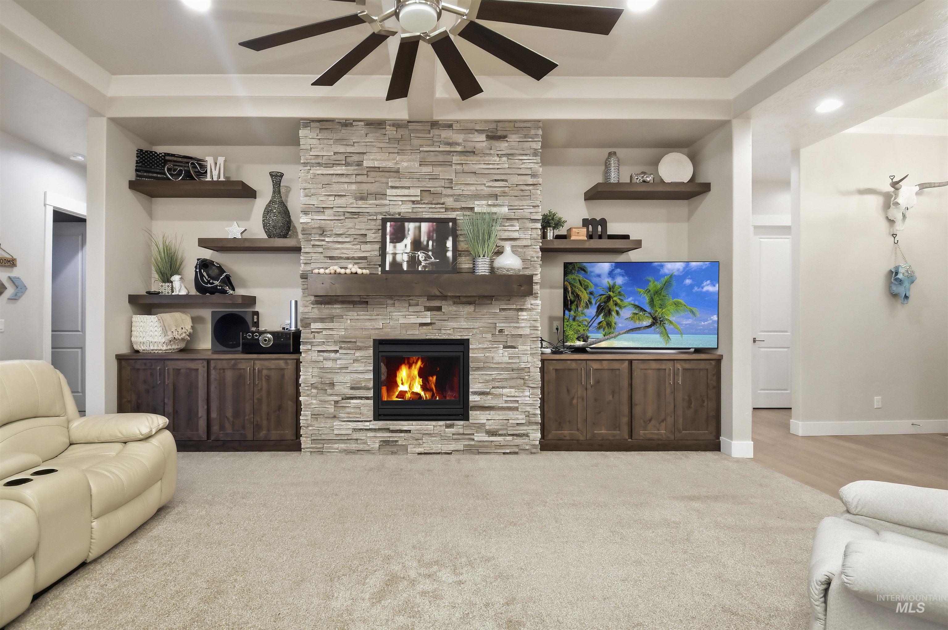 12174 West Lacerta Street Star, ID 83669 - Photo 10 of 49 Living room featuring a ceiling fan, a stone fireplace, carpet flooring, and recessed lighting