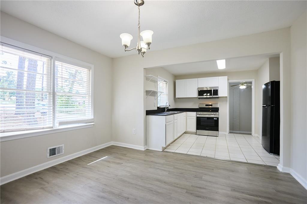 2058 River Road Ellenwood, GA 30294 - Photo 3 of 14 a large kitchen with cabinets wooden floor and stainless steel appliances