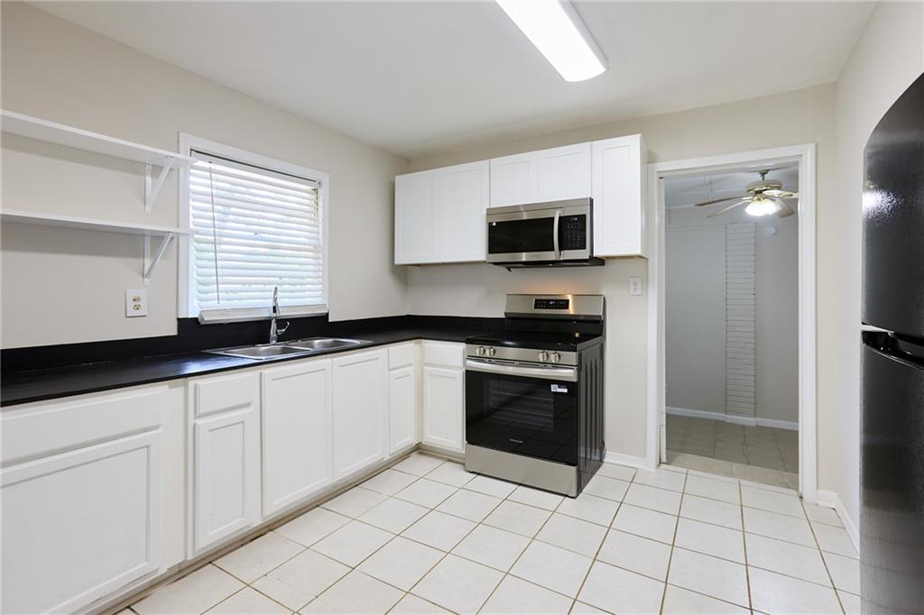 2058 River Road Ellenwood, GA 30294 - Photo 4 of 14 a kitchen with granite countertop a sink and a stove top oven