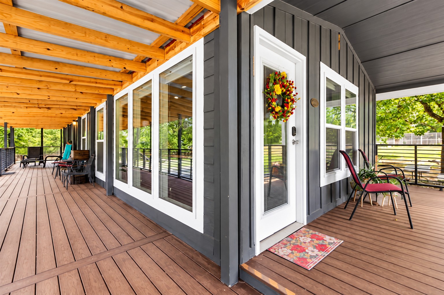 777 Caddo Hills Road Caddo, OK 74729 - Photo 5 of 36 Expansive covered porch featuring wood-finish decking, exposed wood beams, white-framed windows, and a glass-paneled entry door