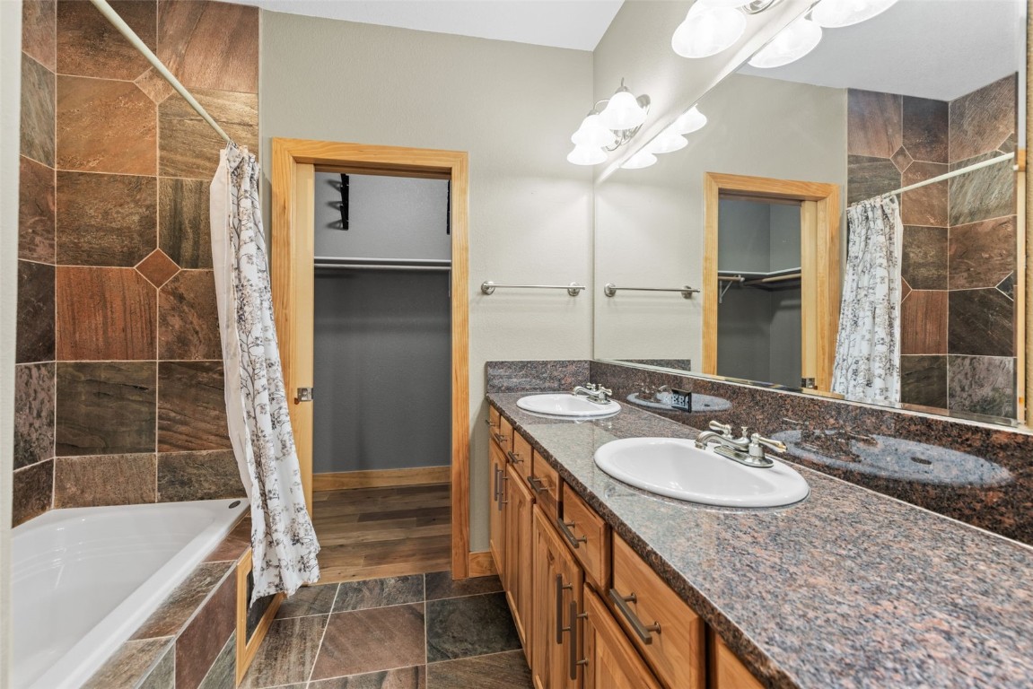 164 Buck Ridge Road, Unit 164 Summit Cove, CO 80435 - Photo 11 of 28 a bathroom with a granite countertop sink and a mirror