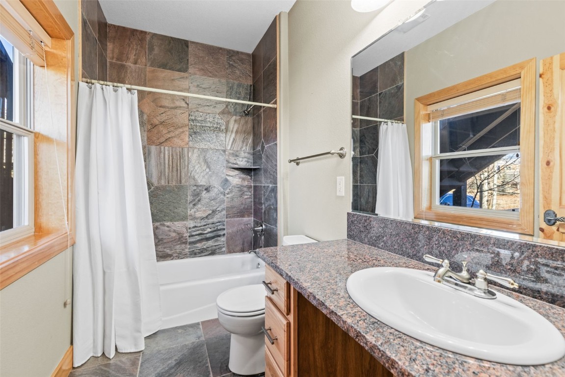 164 Buck Ridge Road, Unit 164 Summit Cove, CO 80435 - Photo 17 of 28 a bathroom with a granite countertop sink toilet and shower