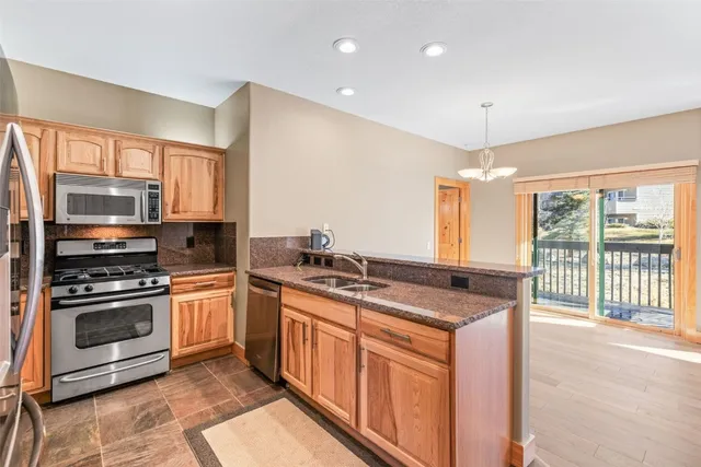 a kitchen with stainless steel appliances granite countertop a stove a sink and a microwave