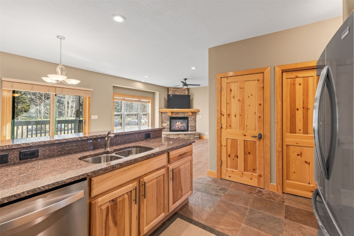 164 Buck Ridge Road, Unit 164 Summit Cove, CO 80435 - Photo 5 of 28 a kitchen with granite countertop a sink and a refrigerator