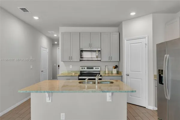 a kitchen with kitchen island a stove a refrigerator and a cabinets