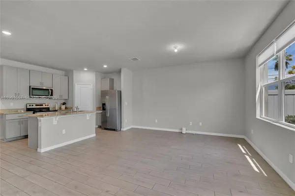 a view of a kitchen with refrigerator a stove top oven a sink and dishwasher with wooden floor