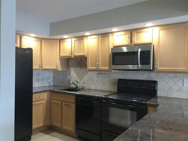 a kitchen with a sink stove and microwave