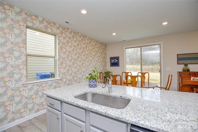 a kitchen with granite countertop a sink and a large window