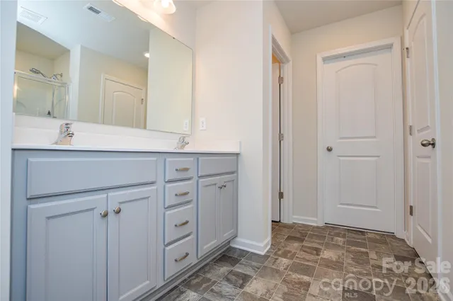 a spacious bathroom with a granite countertop sink a mirror and a