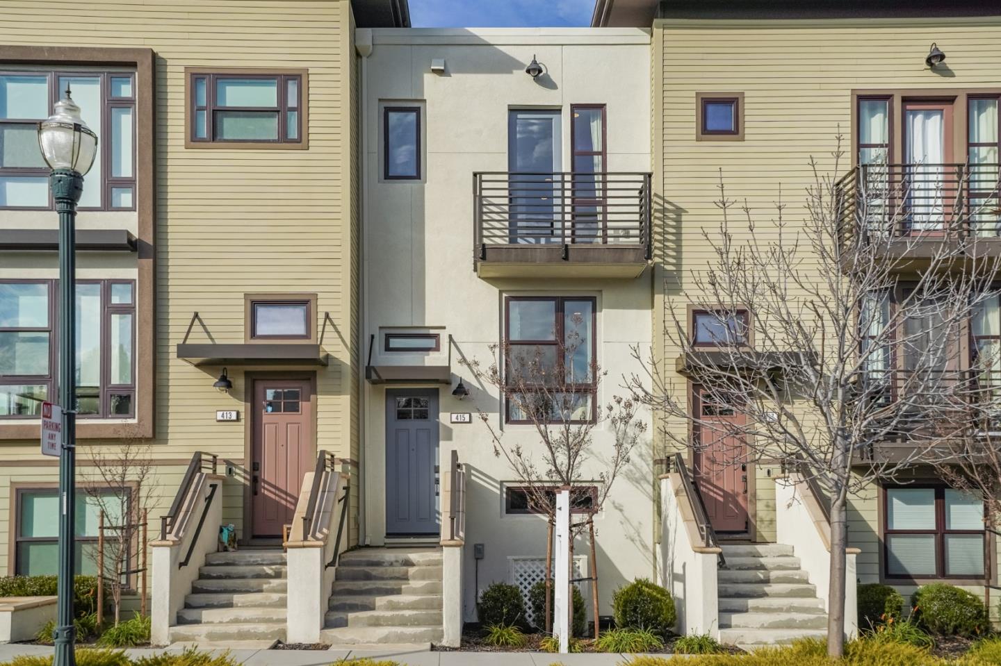 a front view of a house with a tree