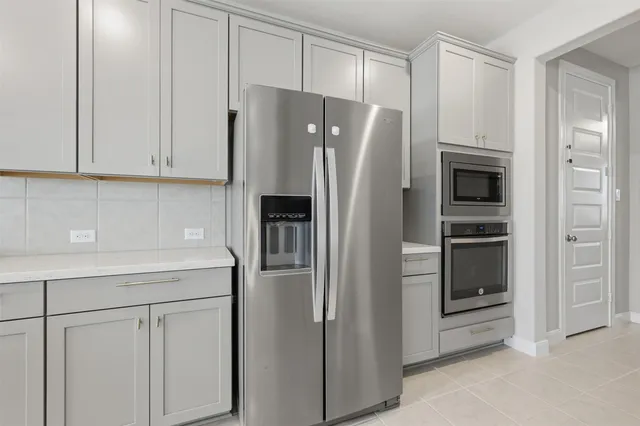 a kitchen with stainless steel appliances granite countertop a sink a stove and a refrigerator