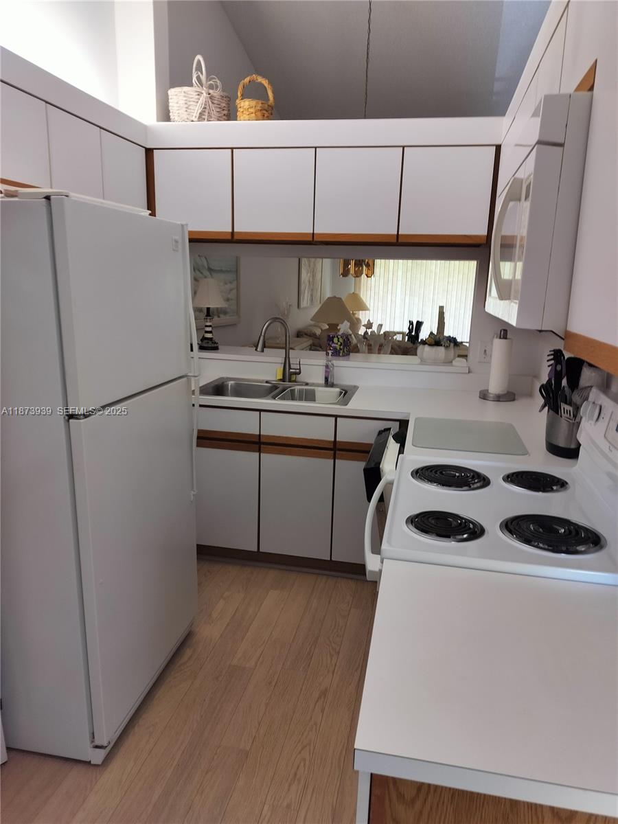 1002 Keystone Drive, Unit F Jupiter, FL 33458 - Photo 2 of 10 a kitchen with a sink a refrigerator a washer and dryer