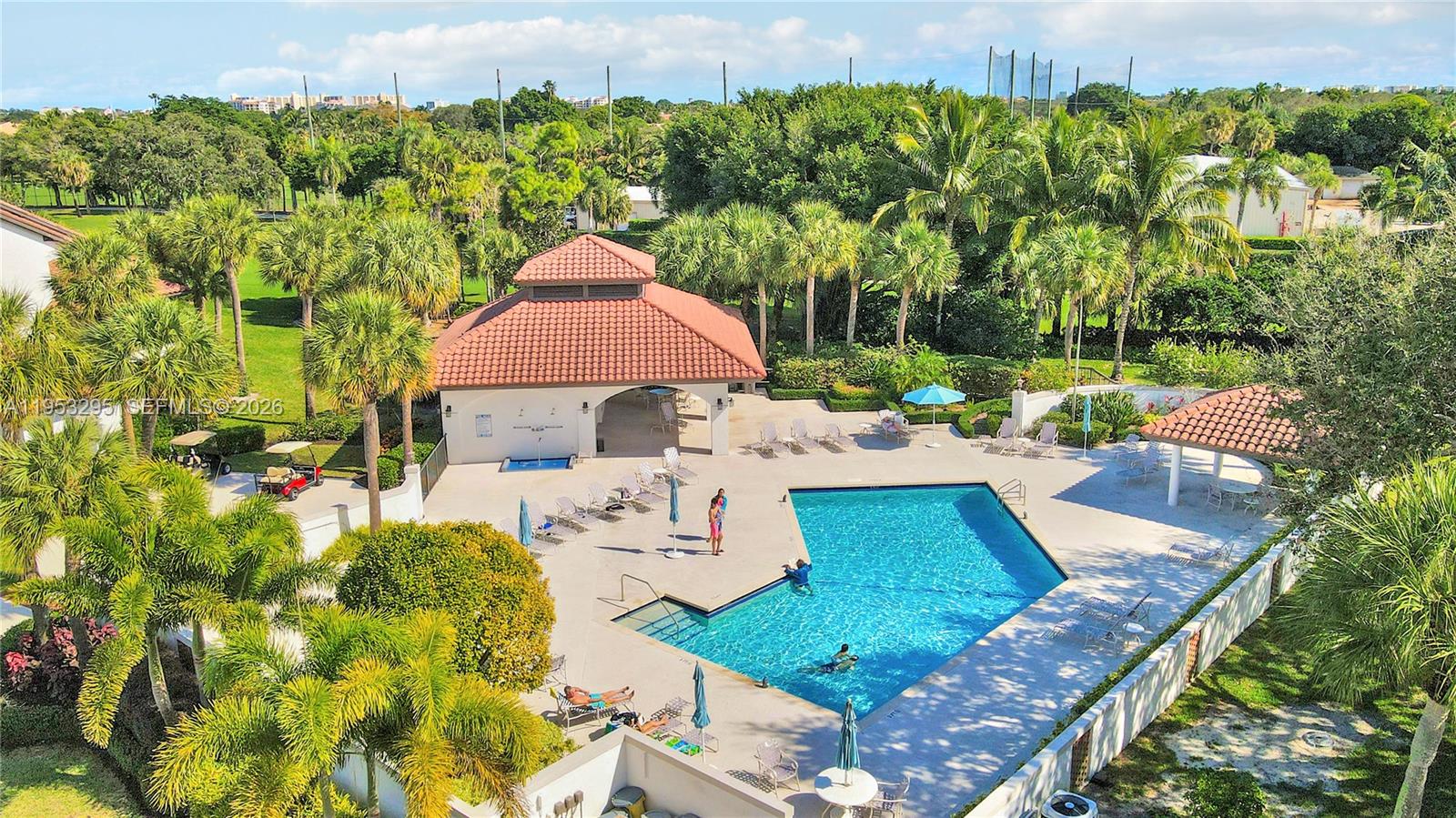 16600 Traders Crossing South, Unit 253 Jupiter, FL 33477 - Photo 13 of 67 a view of a patio with couches table and chairs under an umbrella with large trees