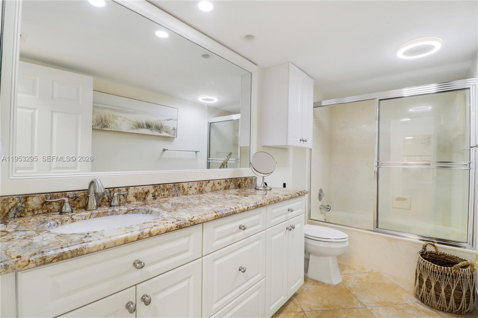 16600 Traders Crossing South, Unit 253 Jupiter, FL 33477 - Photo 34 of 67 a bathroom with a granite countertop sink a toilet and shower