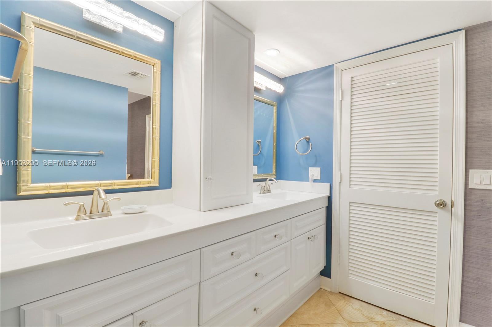 16600 Traders Crossing South, Unit 253 Jupiter, FL 33477 - Photo 45 of 67 a bathroom with a double vanity sink and mirror