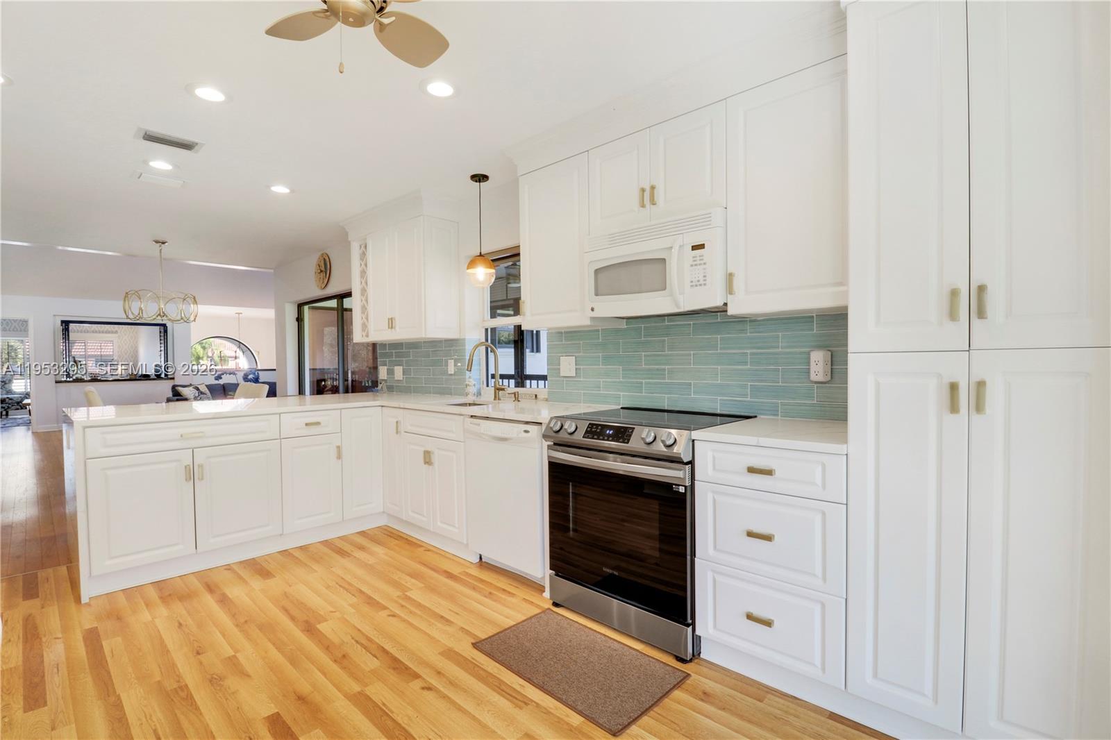 16600 Traders Crossing South, Unit 253 Jupiter, FL 33477 - Photo 55 of 67 a kitchen with stainless steel appliances granite countertop a stove a sink and a refrigerator