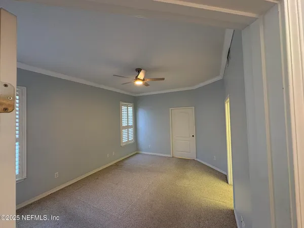 a view of empty room with a ceiling fan and window