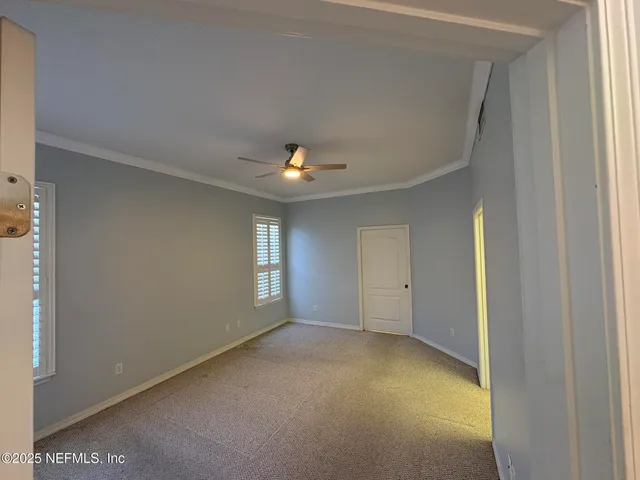 a view of empty room with a ceiling fan and window