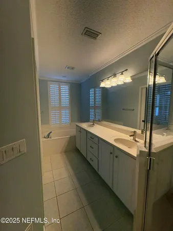 a bathroom with a double vanity sink a mirror and a shower