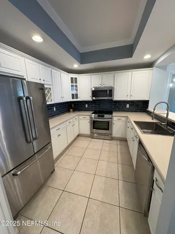a kitchen with stainless steel appliances a refrigerator sink stove microwave and cabinets
