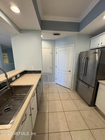 a kitchen with a refrigerator a stove top oven and cabinets