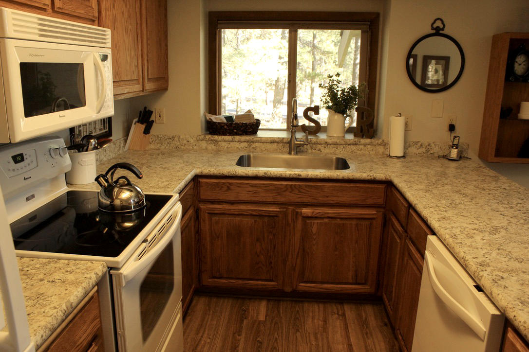 57326-12 Beaver Ridge Loop Sunriver, OR 97707 - Photo 8 of 24 a kitchen with stainless steel appliances granite countertop a sink stove and cabinets