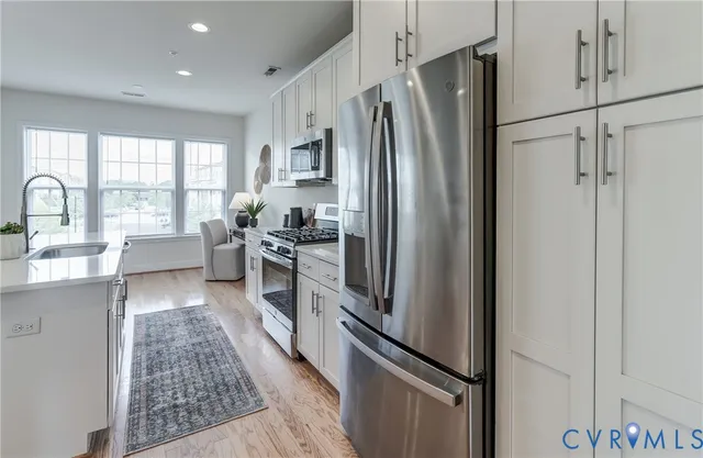 a kitchen with stainless steel appliances granite countertop a refrigerator and a sink