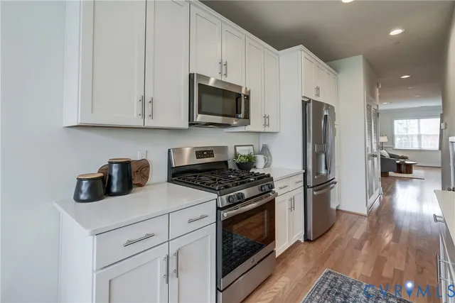 a kitchen with stainless steel appliances granite countertop a stove a refrigerator and a microwave