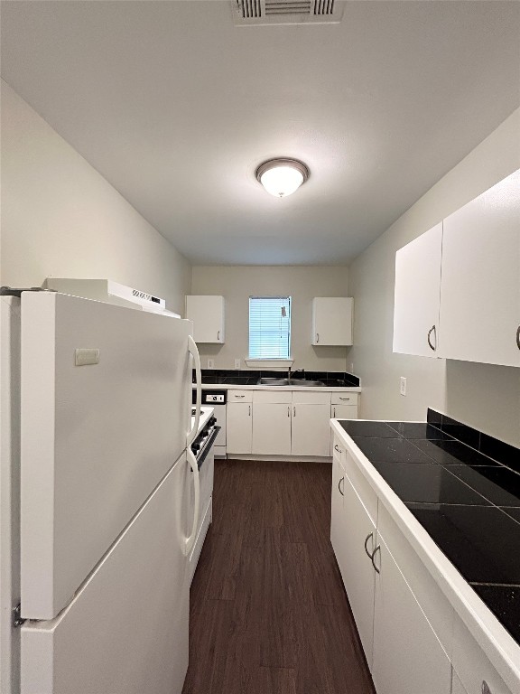 3629 North MacGregor Way, Unit 131 Houston, TX 77004 - Photo 7 of 13 a kitchen with granite countertop a refrigerator a sink and white cabinets