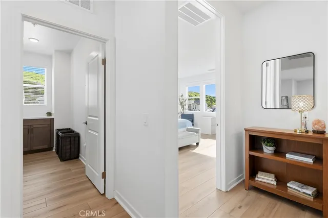 a walk in closet with wooden floor