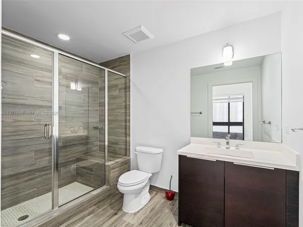 a bathroom with a sink a toilet and shower