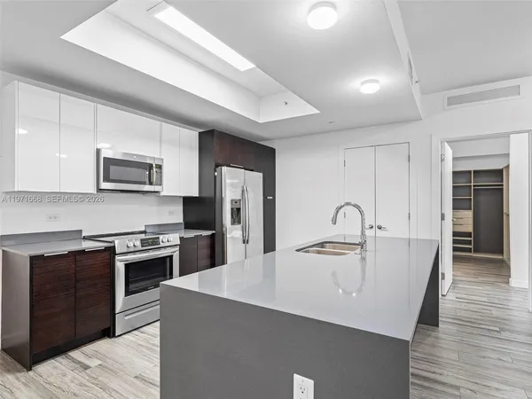 a kitchen with stainless steel appliances granite countertop a sink dishwasher stove top oven and refrigerator